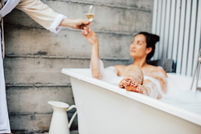 woman in spa bath having champagne