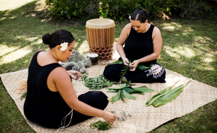 Women weaving leis