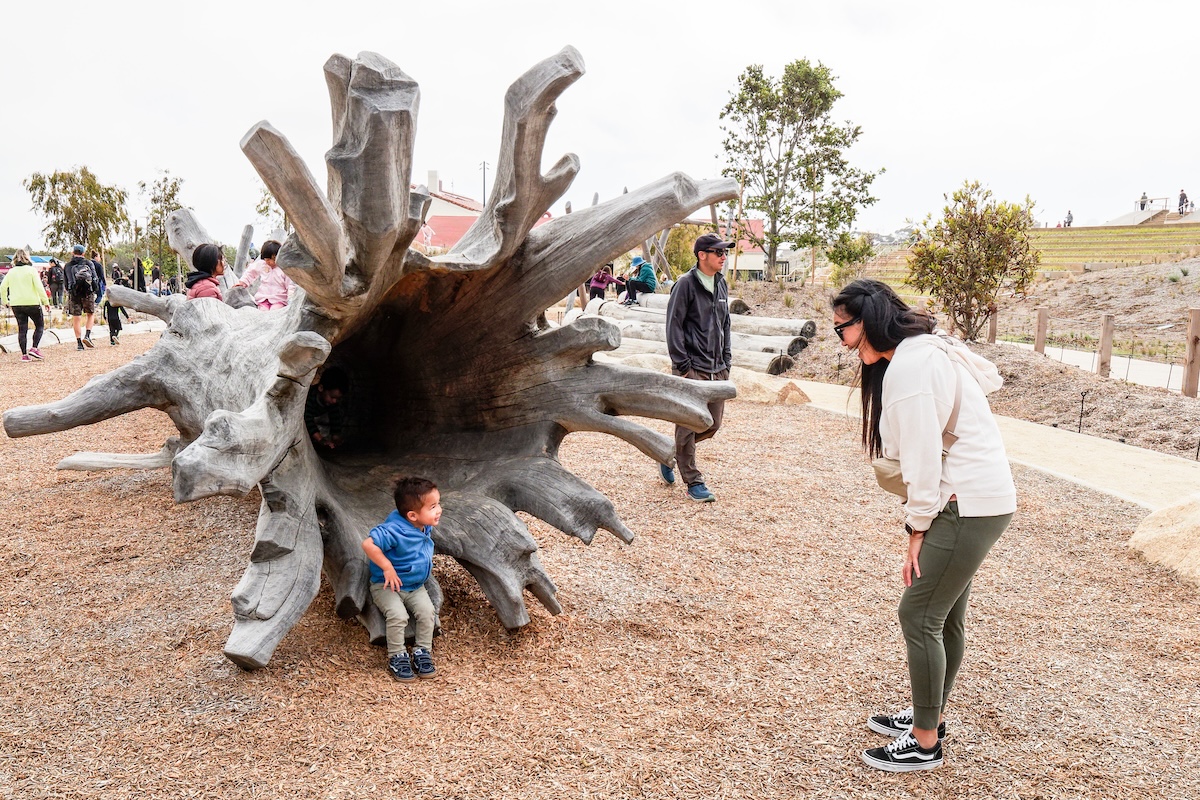 Child on playground log at Presidio Tunnel Tops Park.