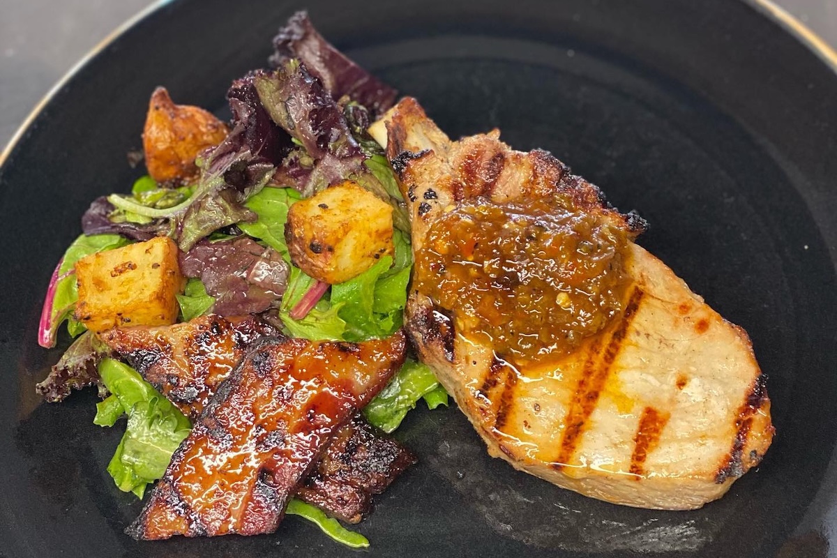 Grilled chicken with lettuce and cubes of something fried.