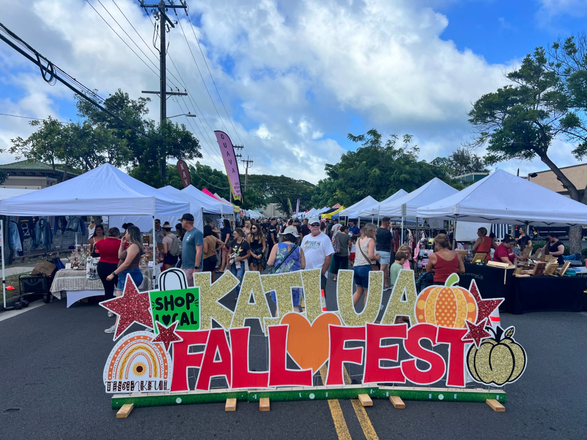 Crowds browse vendor booths at the outdoor Kailua Fall Fest, with a colorful sign reading “Fall Fest” at the entrance.