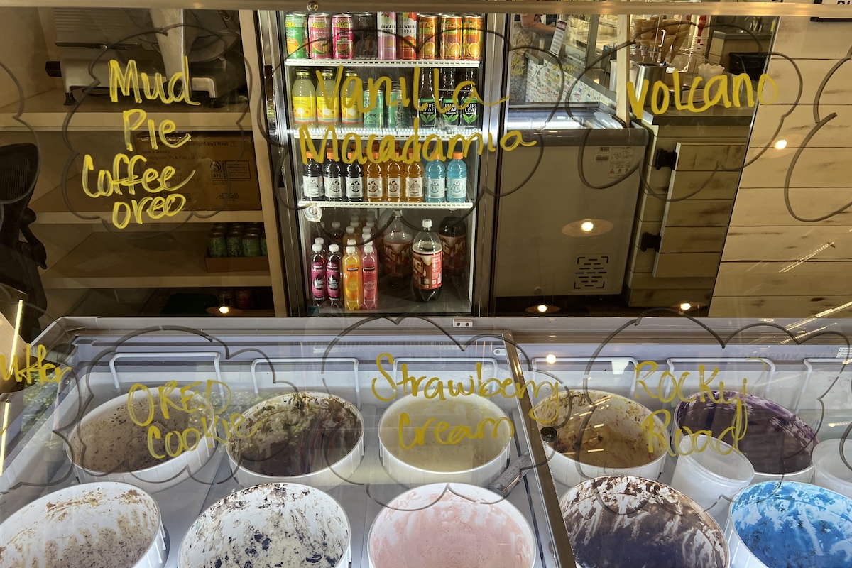Rows of ice cream buckets and signs with the flavors.