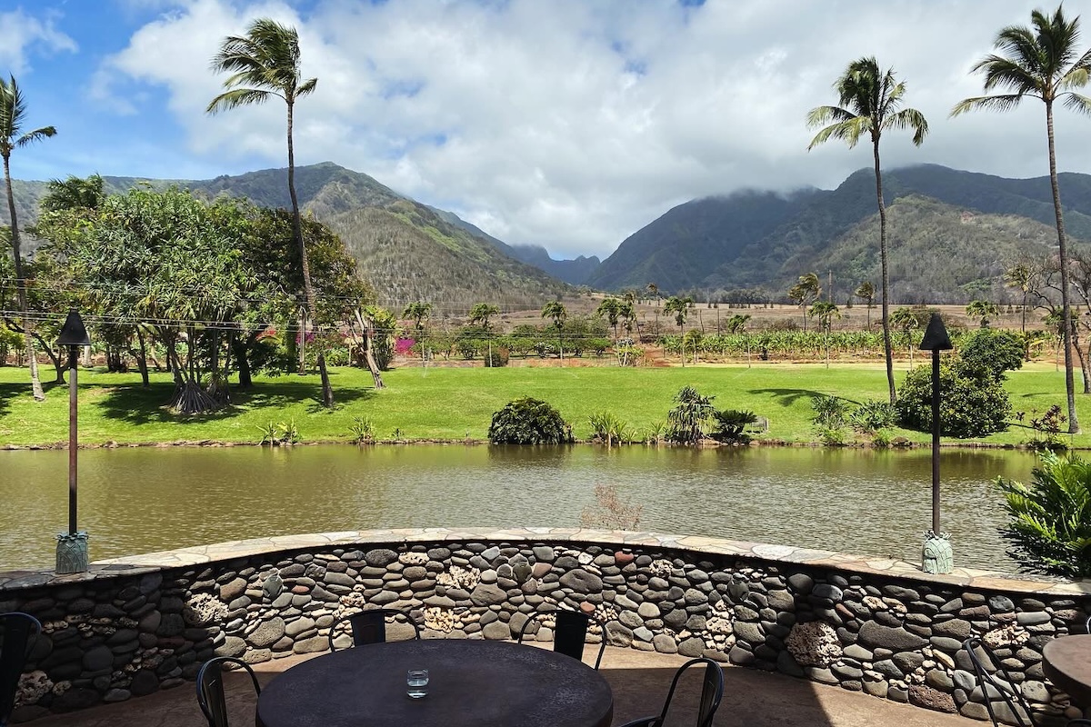 An outdoor patio overlooking some water and a view of mountains.