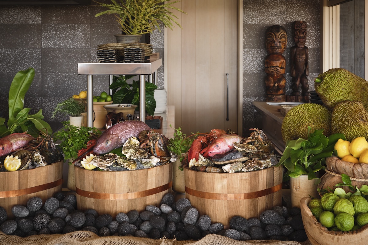 Barrels topped with various shellfish, fish and fruits.