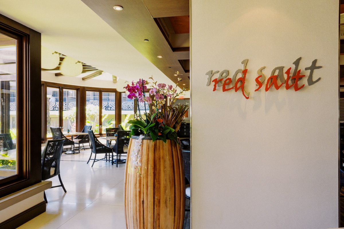 A sign that says "Red Salt" with a view of the restaurant's interior.