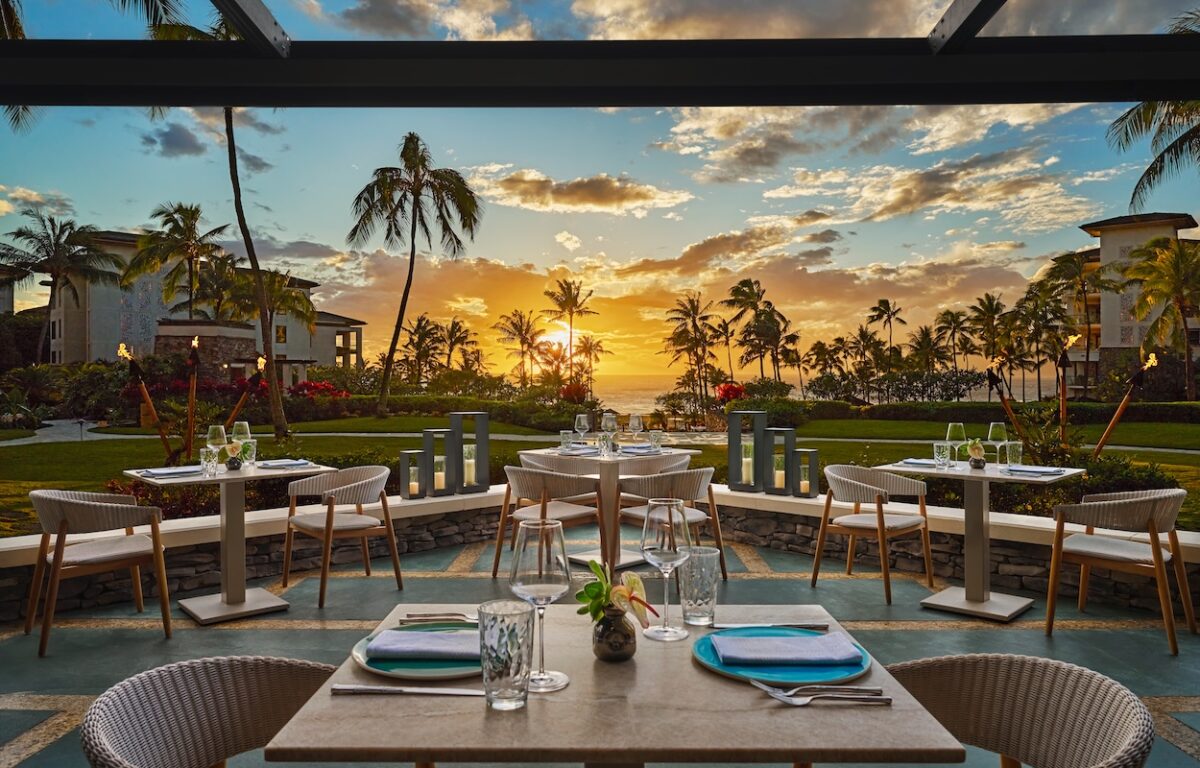 A table set outside with a sunset in the background.
