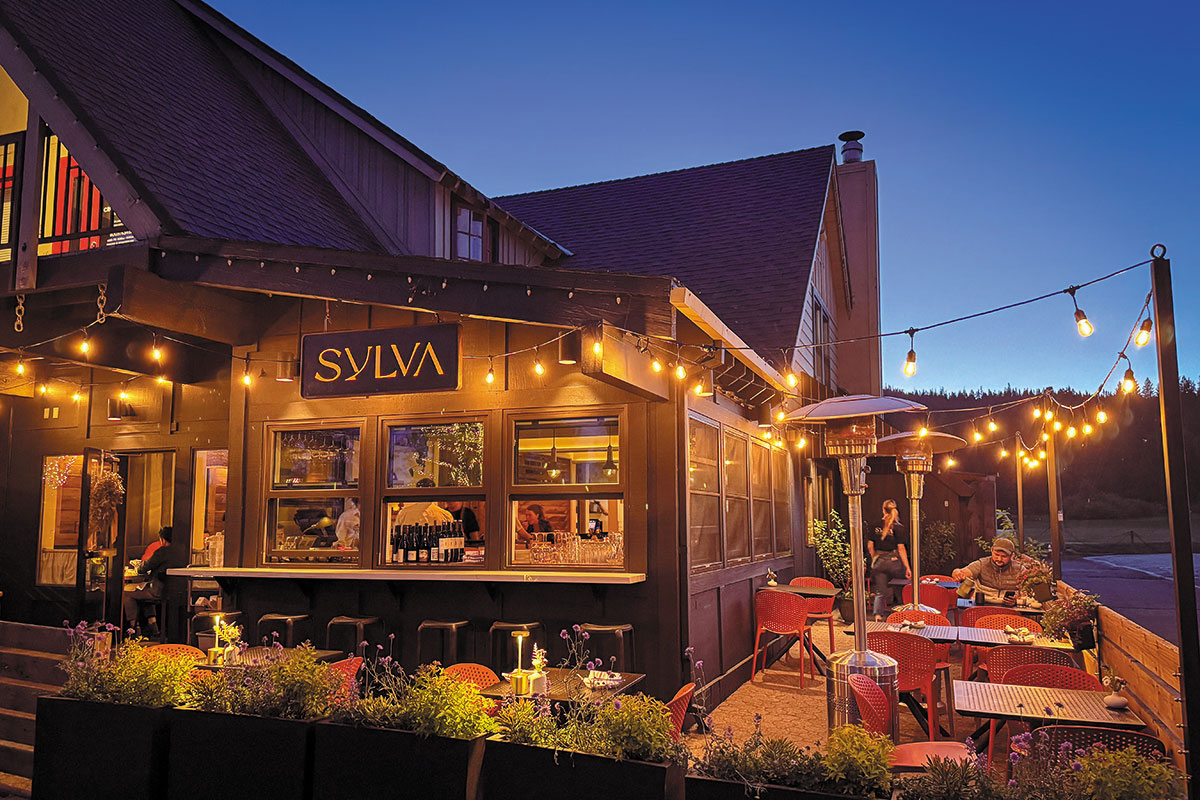The outside of a restaurant decorated with twinkling string lights, enhancing its charm and ambiance at night.