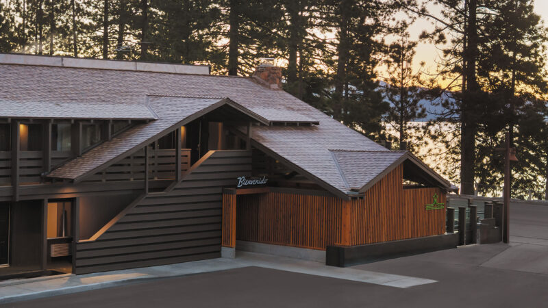 Contemporary house with a wooden roof and a driveway, set in a landscaped environment.