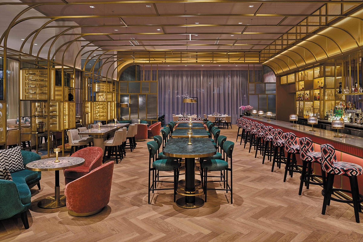 The hotel bar features elegant gold and red decor, creating a luxurious and inviting atmosphere for guests.