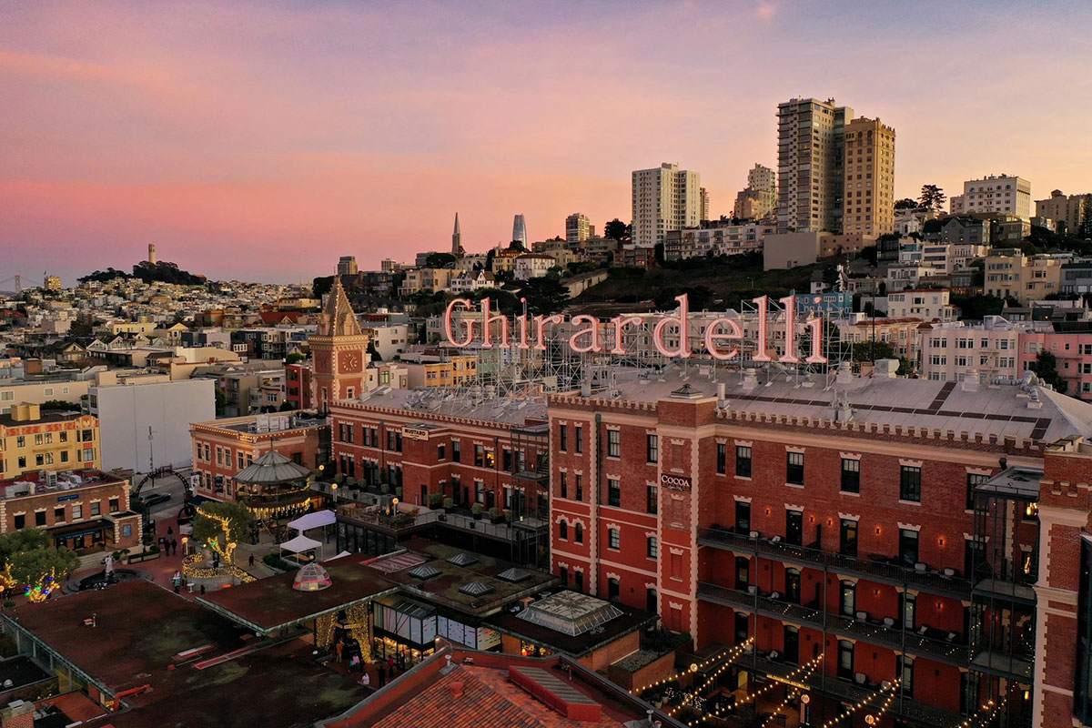 The San Francisco skyline at sunset, featuring iconic buildings bathed in warm colors of the setting sun.