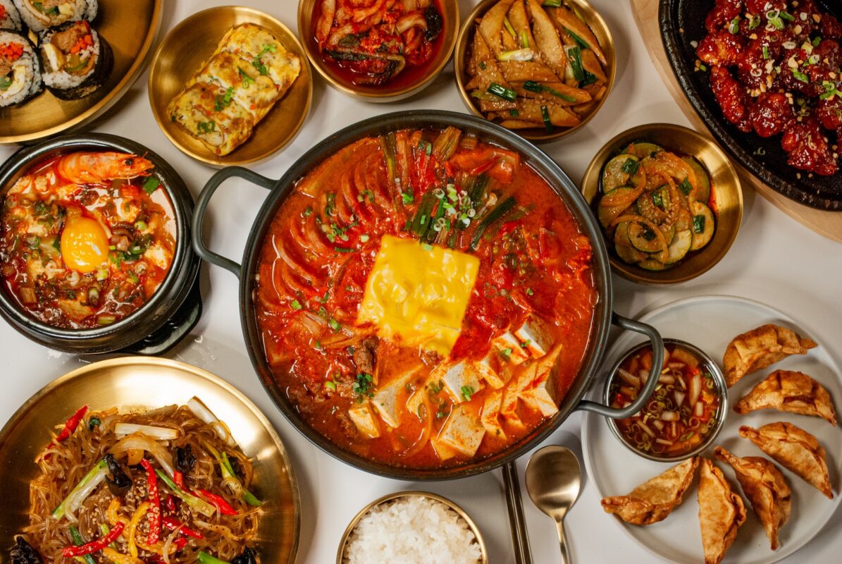 An aerial shot of plates of Korean-style food including hotpot in the middle.