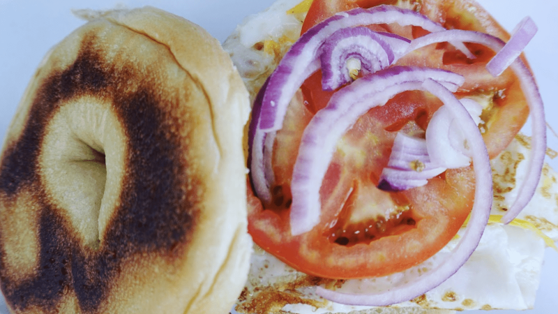 A bagel with tomato and onion for the best breakfast in the East Bay