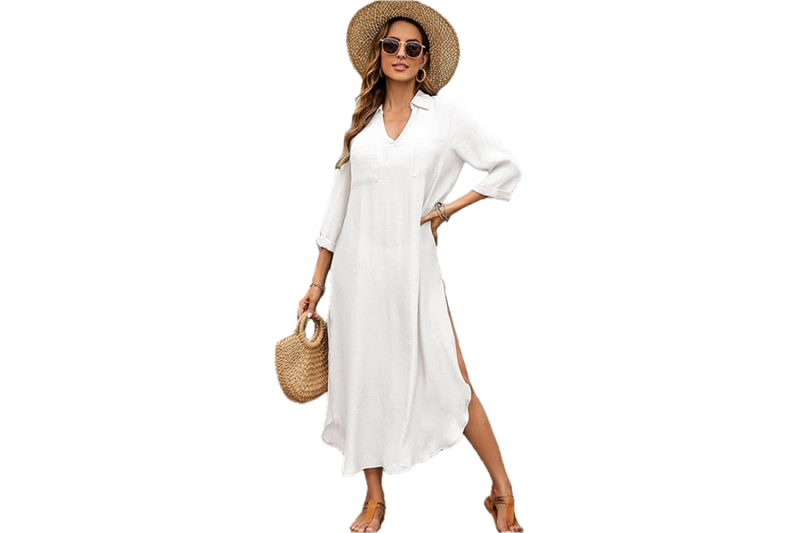 A woman wearing a sun hat, carrying a straw purse, and dressed in an ankle-length white shirtdress.
