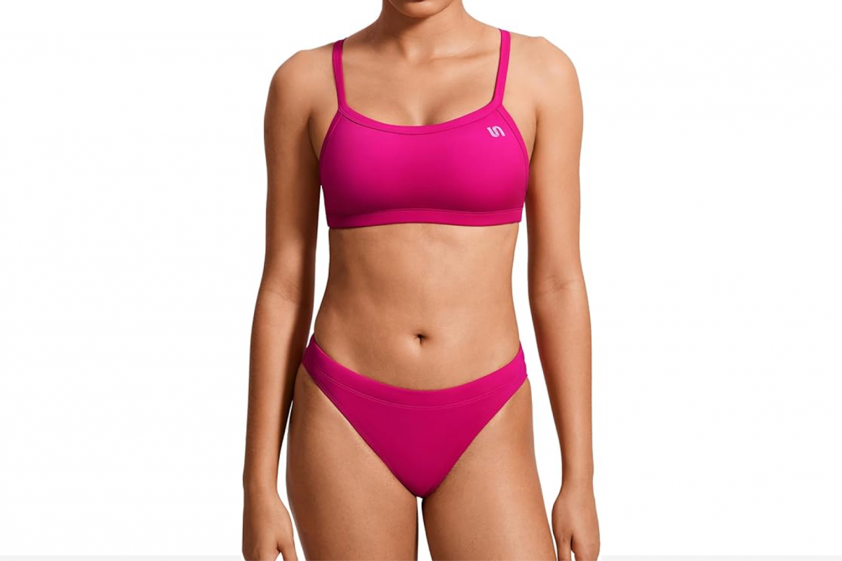 This image features a woman's torso wearing a pink two piece swimsuit