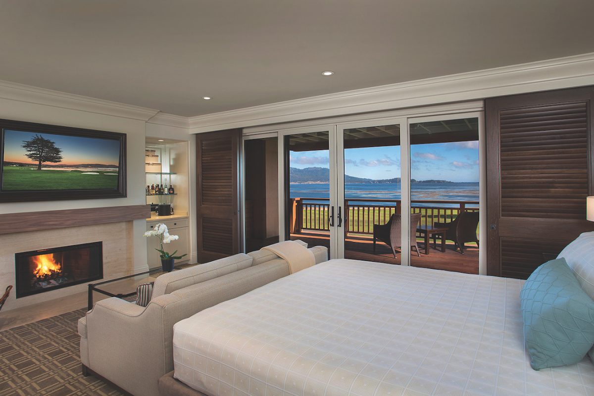 Luxury hotels Monterey - Hotel room with bed, couch, fireplace and balcony overlooking the bay at The Lodge at Pebble Beach in Monterey, California.