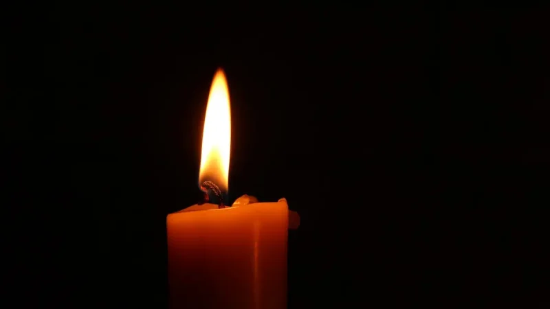 A single candle burning in darkness