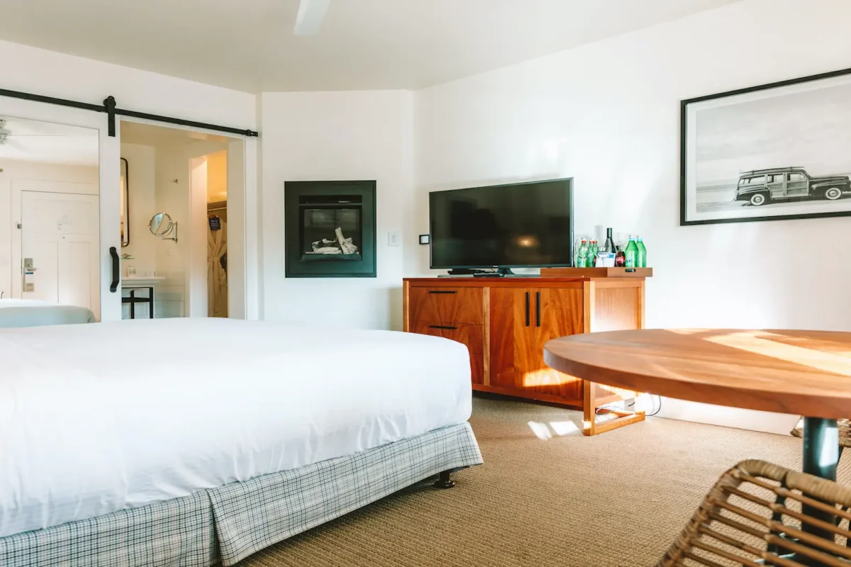 Hotel room with bed, table, TV and fire place at the Getaway (now known as Le Petit Pali) in Monterey, California